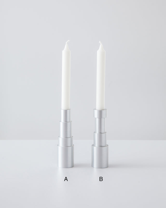 Different type of elegant aluminum candle holders with white candles, set against a white background depicting 2 different types of candle holders.